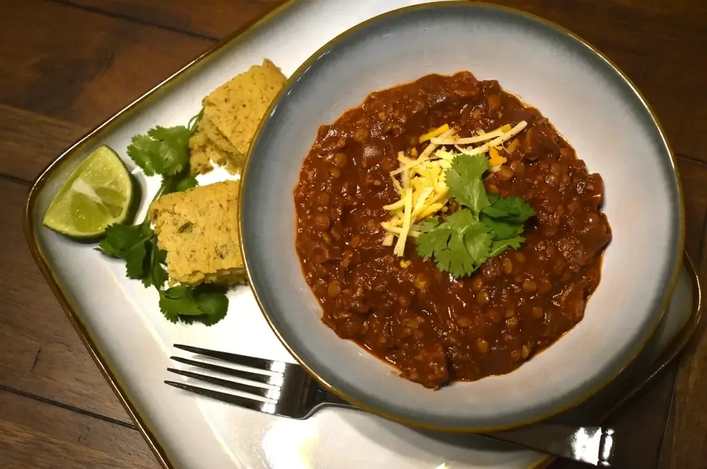 completed chili served with cornbread and lime